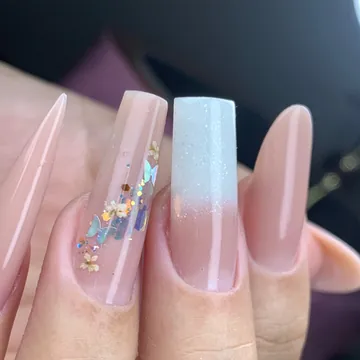 Unhas longas nude com encapsulada de glitter e uma unha degradê branca, feitas por aluna do VIP