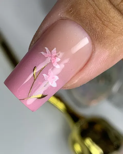 Unha rosa com flor desenhada sobre alongamento em gel