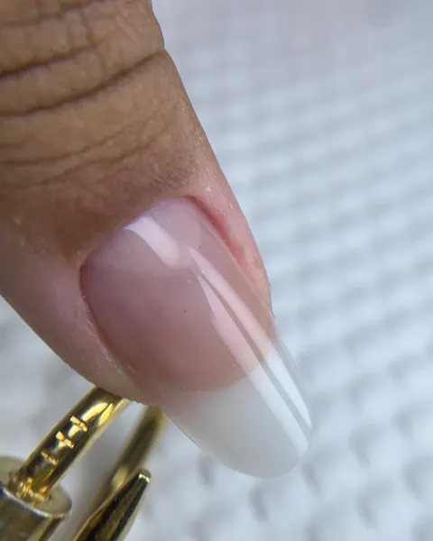 Unha alongada fina e com aparência natural, em gel milk, vista de perfil