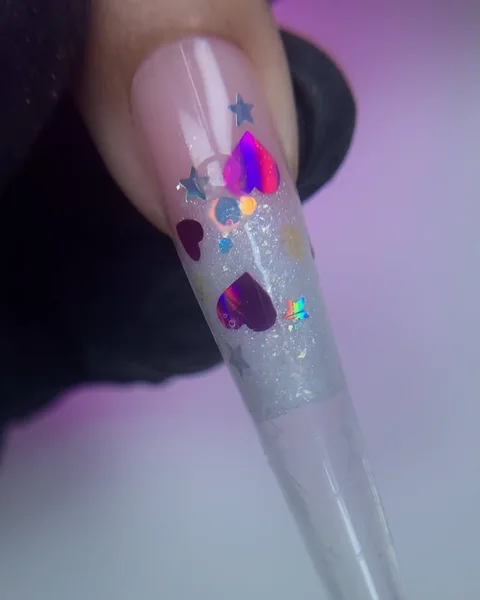 Unha stiletto longa no Molde F1, com encapsulado de corações e estrelas holográficas e ponta transparente